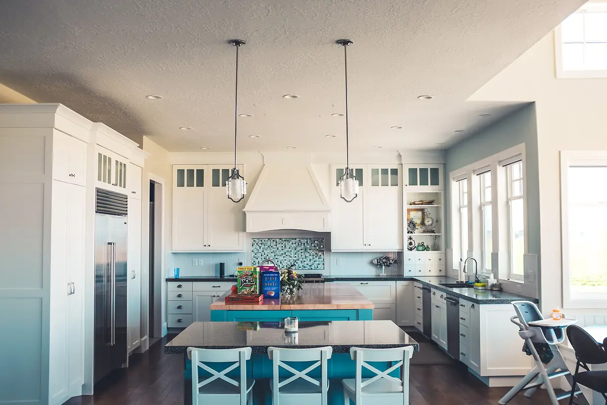 White painted kitchen cabinets with glass upper doors and a butcher block island, the kind of custom cabinet work done in Riverside CA